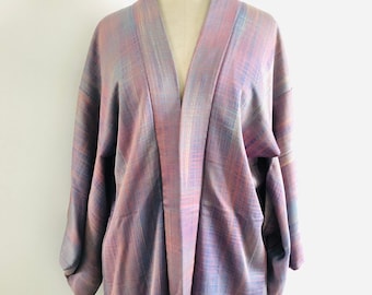 Könnte beinhalten: Ein lila und blauer Kimono mit langem Ärmel. Der Kimono ist aus einem weichen, seidenartigen Stoff.
