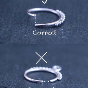 May include: A close-up of a silver nose ring with a row of small beads. The image shows the correct and incorrect way to measure the ring. The correct way is to measure the inside diameter of the ring, while the incorrect way is to measure the outside diameter.