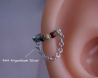 May include: A silver chain earring with a row of colorful beads. The beads are turquoise, black, white, red, and green. The earring is made of 940 Argentium silver.