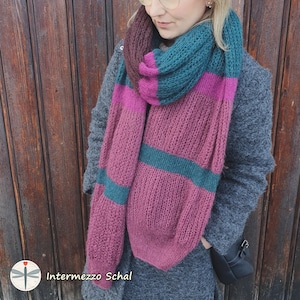 May include: A pink, teal, and brown striped knitted scarf with the text "Intermezzo Schal" on the bottom left corner.