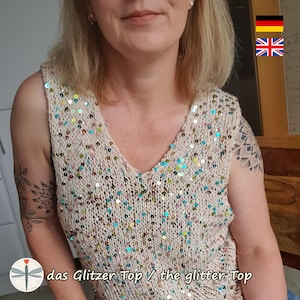 Pode incluir: Um top sem mangas de cor branco-creme com decote em V e um design brilhante de lantejoulas. As lantejoulas são de várias cores, incluindo rosa, azul e verde. O texto "das Glitzer Top / the glitter Top" está na parte inferior da imagem.