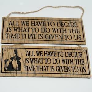 May include: Two wooden signs with the quote "All we have to decide is what to do with the time that is given to us." The top sign is plain wood, while the bottom sign features a cartoon image of a wizard.
