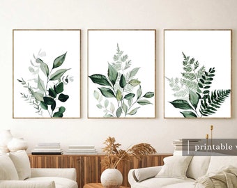 Peut inclure: Trois impressions aquarelle de feuillage vert sur fond blanc. Les impressions sont encadrées dans un cadre simple en bois clair et sont accrochées à un mur blanc. Les impressions sont disposées en rangée, l'impression la plus à gauche présentant un groupe de feuilles, l'impression du milieu présentant une fougère et l'impression la plus à droite présentant un autre type de fougère.