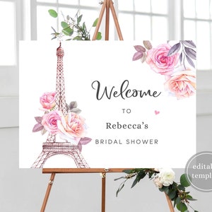 May include: A printable welcome sign for a bridal shower with a pink and white floral design and an illustration of the Eiffel Tower. The text reads "Welcome to Rebecca's Bridal Shower".