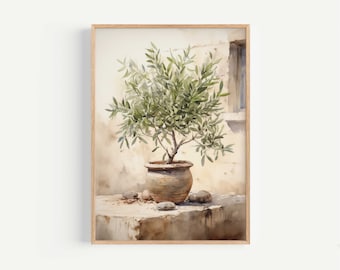 May include: Watercolour painting of an olive tree in a terracotta pot. The artwork is framed in a light wood frame. The tree has green leaves and is set against a beige wall with a small window.