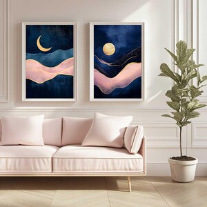 May include: Two abstract landscape paintings with a blue background, pink and gold accents, and a crescent moon and full moon in the sky.