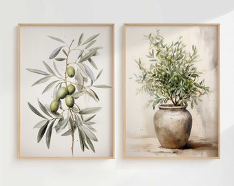 May include: Two framed watercolor paintings of olive branches. The painting on the left shows a single branch with green olives. The painting on the right shows a potted olive tree with green olives.