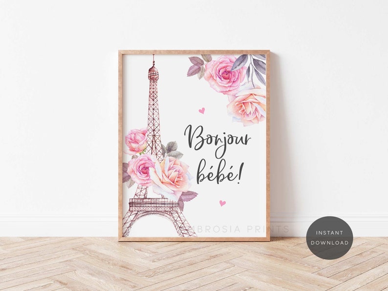 May include: A printable art print featuring a watercolor illustration of the Eiffel Tower with pink and peach flowers. The text "Bonjour b&eacute;b&eacute;!" is written in black cursive font.