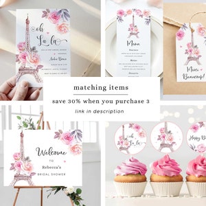 Op de afbeelding: Een set printbare bruidsdouche-decoraties met een roze en wit Eiffeltoren-ontwerp met bloemmotieven. De set bevat een welkomstbord, uitnodigingen, cupcake-toppers en een menukaart. De tekst op de uitnodigingen luidt "Oh La La" en de tekst op het welkomstbord luidt "Welkom bij Rebecca's Bridal Shower".
