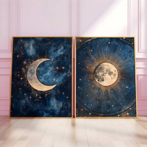 May include: Two framed prints with a celestial theme. The first print features a crescent moon with a gold outline against a dark blue background with stars. The second print features a full moon with a gold halo against a dark blue background with stars.