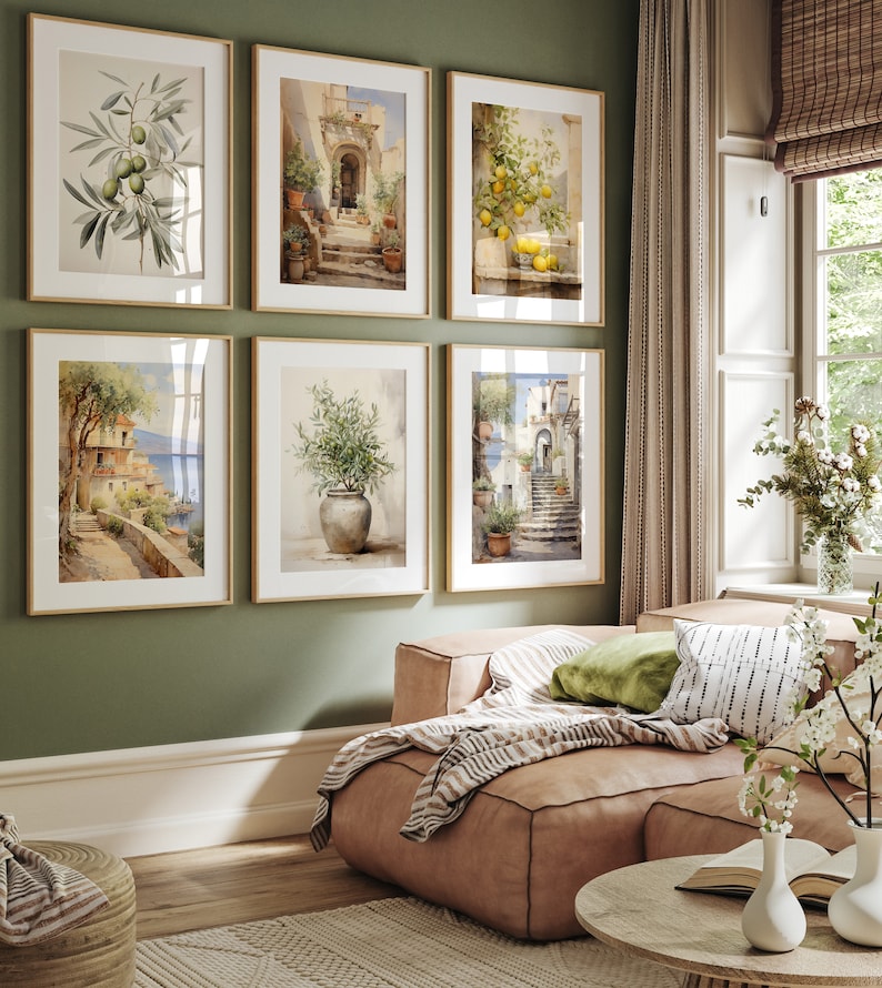 Peut inclure: Six aquarelles encadr&eacute;es repr&eacute;sentant des sc&egrave;nes italiennes, dont un citronnier, une branche d'olivier en pot et une vue d'une ville c&ocirc;ti&egrave;re. Les tableaux sont accroch&eacute;s &agrave; un mur vert dans un salon.
