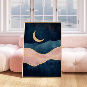 May include: Abstract art print featuring a crescent moon in gold against a dark blue background with pink and gold accents. The print depicts a stylized landscape with rolling hills and a starry sky.