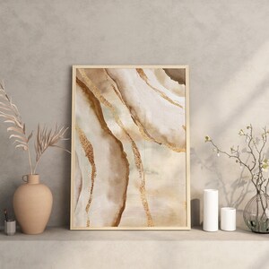 Peut inclure: Une impression abstraite encadr&eacute;e avec un fond beige et brun et des accents dor&eacute;s. L'impression pr&eacute;sente un design marbr&eacute; tourbillonnant.