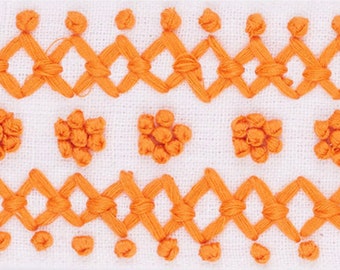 May include: Orange embroidery stitch pattern on white fabric. The pattern includes a repeating diamond shape and a cluster of small circles.