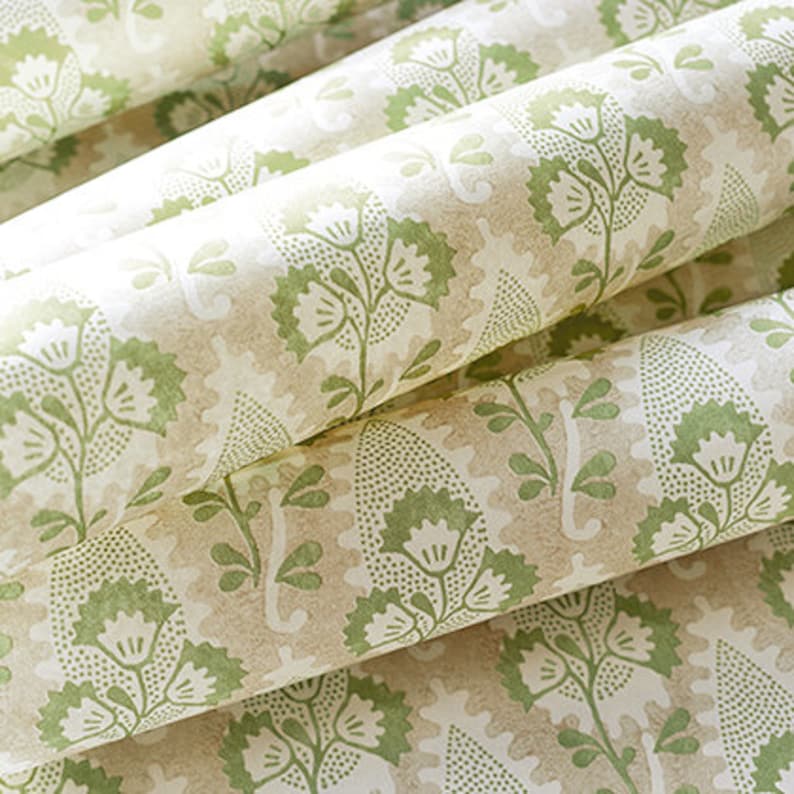 May include: Close-up of a beige and green patterned fabric with a floral design. The fabric has a subtle texture and a soft, muted color palette.