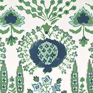 May include: A white background with a green and blue floral pattern. The pattern features stylised flowers, leaves, and a central motif resembling a stylised heart.