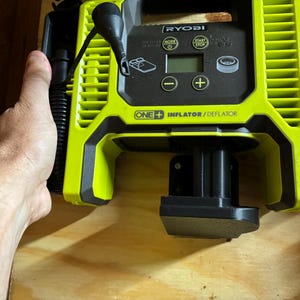 May include: A green and black Ryobi One+ Inflator/Deflator with a digital display and a black hose. The device is plugged into a black power source.