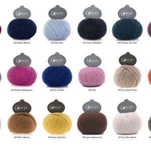 May include: A collection of colorful yarn balls in various shades, including cranberry, navy, and baby blue. Each ball has a label with a number and color name. The yarn is likely for knitting or crochet projects.