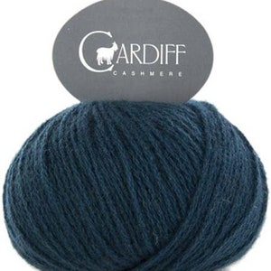 May include: A ball of dark blue cashmere yarn with a label that reads "CARDIFF CASHMERE" and features a small goat illustration.