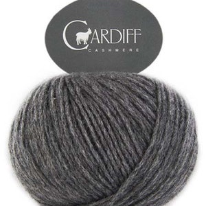 May include: A ball of dark gray yarn with a label that reads "CARDIFF CASHMERE" and features a small goat illustration.