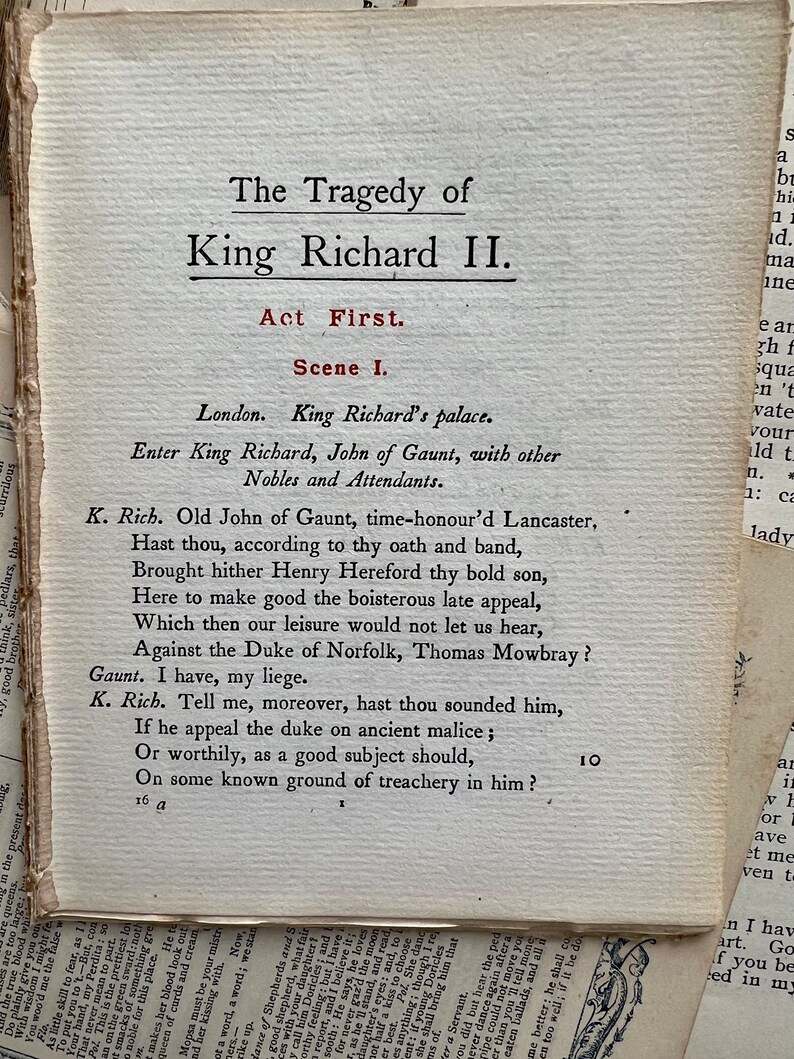 May include: A page from a vintage book of Shakespeare's play, King Richard II. The text is printed in black ink on a cream-colored page. The title of the play is printed in bold, black letters at the top of the page. The text is in a traditional font style.
