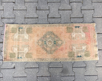 May include: A vintage runner rug with a faded peach background and a geometric pattern in shades of green and white.