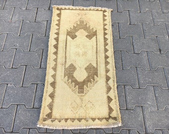 May include: A beige and brown patterned rug with a geometric design. The rug has a fringe border.