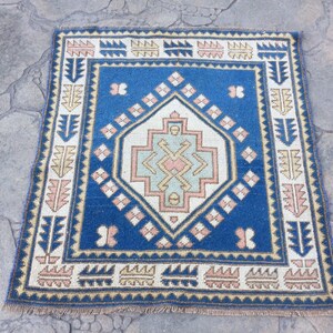 May include: A blue and cream patterned rug with a geometric design. The rug has a fringe border and is made of wool.