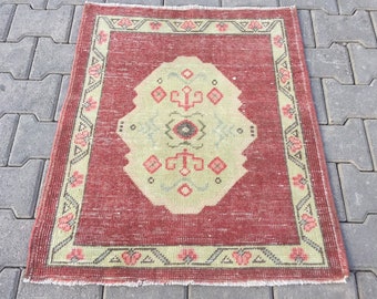 May include: A vintage red and cream rug with a floral pattern. The rug has a fringed edge and is made of wool.