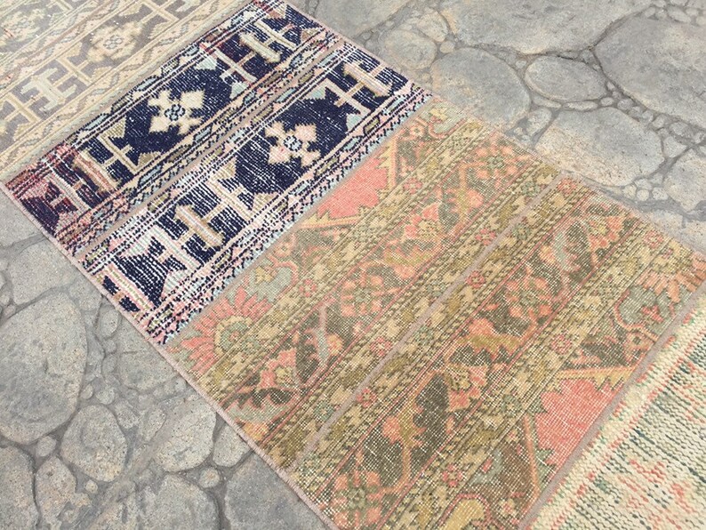 May include: A multi-colored vintage rug with a geometric pattern. The rug is made up of several different pieces of fabric sewn together. The rug is a mix of pink, blue, green, and brown.