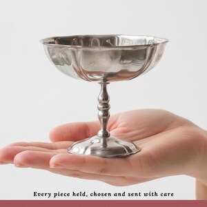 Peut inclure: Une coupe &agrave; champagne vintage argent&eacute;e avec un bol cannel&eacute; et un piedestal. Le texte indique : "Every piece held, chosen and sent with care. AUTHENTIC FRENCH VINTAGE SOURCED IN FRANCE."