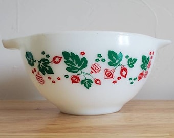 May include: White mixing bowl with a green and red Christmas ornament design. The bowl has a pouring spout on one side.