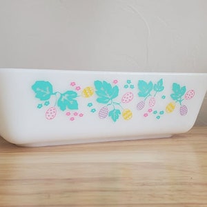 May include: White rectangular baking dish with a green, pink, and yellow floral design. The design features a repeating pattern of leaves and berries.