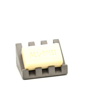 May include: A gray soap dish with a rectangular soap bar that says "ALL-ONE!" on it.