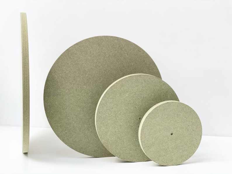 Peut inclure: Quatre disques ronds en bois de couleur beige de tailles diff&eacute;rentes. Les disques sont empil&eacute;s les uns sur les autres, le plus grand en bas et le plus petit en haut.