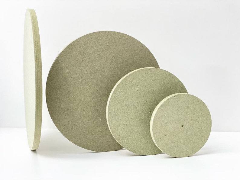 Peut inclure: Quatre disques ronds en bois beige de tailles diff&eacute;rentes. Les disques sont empil&eacute;s les uns sur les autres, le plus grand en bas et le plus petit en haut.