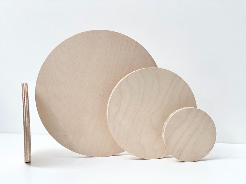 May include: Three unfinished wooden circles of varying sizes. The circles are made of light-colored wood and have a smooth surface.