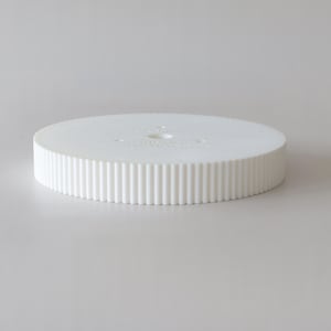 Könnte beinhalten: Weißer Kuchenständer aus Kunststoff mit geriffeltem Rand und einem kleinen Loch in der Mitte.