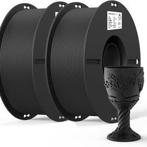 May include: Three spools of black filament for 3D printing. The filament is wound around a black plastic spool with a label that reads "Ender 3 Pro". A black plastic goblet with a tree design is in the foreground.