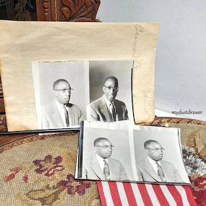 May include: Black and white vintage photographs of a man wearing glasses and a suit. The photos are arranged with a large, aged paper and a decorative, patterned surface. The text "Cannon Portrait" is visible on the paper.