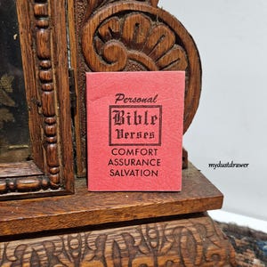 May include: A small red booklet with the title "Personal Bible Verses" and the words "Comfort, Assurance, Salvation" printed on the front.