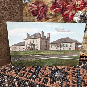 May include: Vintage postcard showing a brick building with a large front porch. The building is labeled "State Hospital, Pennsylvania Ave."