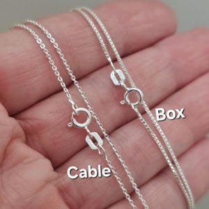 May include: Two silver chains, one labeled "Cable" and the other labeled "Box".