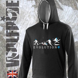 Puede incluir: Sudadera con capucha negra con un gráfico blanco de esquiadores en varias poses. El gráfico incluye la palabra "EVOLUTION" y una estrella.