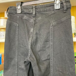 Pu&ograve; includere: Jeans in denim nero a vita alta e gambe dritte. I jeans hanno un particolare dettaglio di cucitura sul davanti di ogni gamba.