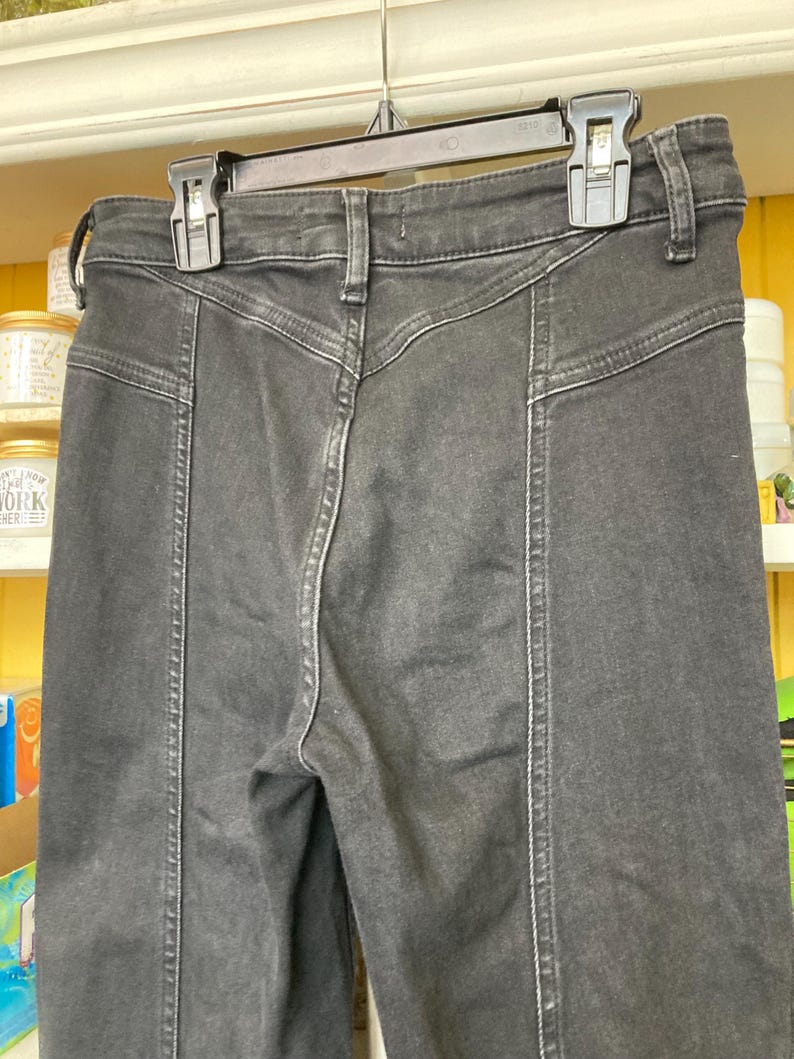 Pu&ograve; includere: Jeans in denim nero a vita alta e gambe dritte. I jeans hanno un particolare dettaglio di cucitura sul davanti di ogni gamba.