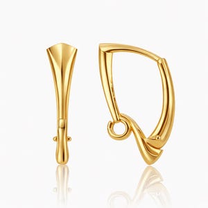 Pu&ograve; includere: Un paio di orecchini color oro. Uno &egrave; un design curvo e aperto con un piccolo anello in basso. L'altro &egrave; una forma verticale e allungata con la parte superiore svasata e un piccolo perno.