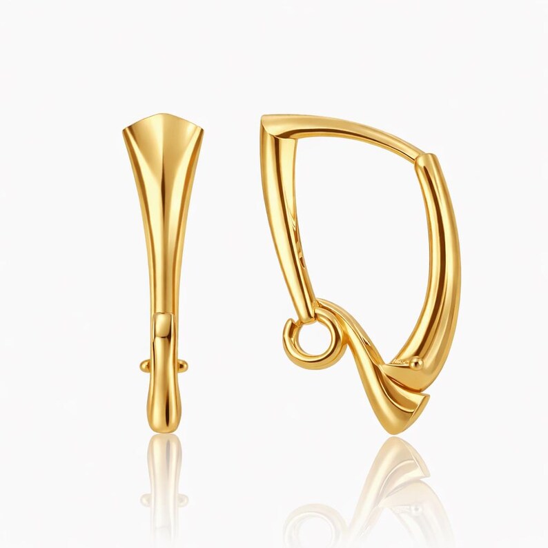 Pu&ograve; includere: Un paio di orecchini color oro. Uno &egrave; un design curvo e aperto con un piccolo anello in basso. L'altro &egrave; una forma verticale e allungata con la parte superiore svasata e un piccolo perno.