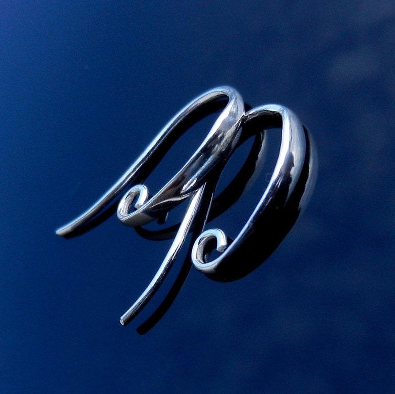 May include: Two silver earring hooks with a curved design. The hooks are made of metal and have a shiny finish.