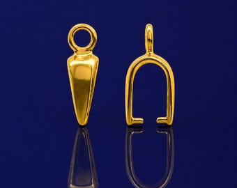 Pode incluir: Duas peças de joalheria douradas são exibidas em um fundo azul escuro. Uma é uma fiança de pingente em forma de gota com uma argola na parte superior. A outra é uma fiança em forma de U com uma argola na parte superior e duas extremidades planas.